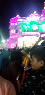 Vibrant festival night scene with an illuminated temple and crowd.