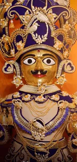 Intricate golden deity with blue adornments on an orange background.