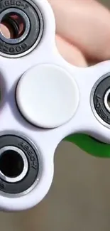 Vibrant green and white fidget spinner in hand.