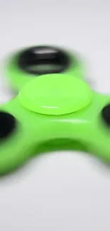 Vibrant green fidget spinner against white background.