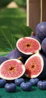 Fresh figs and blueberries on display with vibrant green leaves.