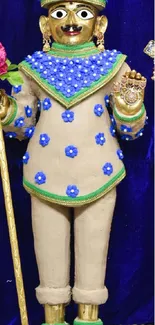 Elegant figurine in blue flowered attire with staff and bouquet.