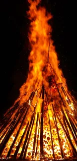 Bonfire burning intensely against a night sky.