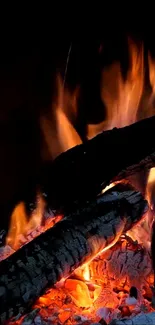 Close-up of glowing fireplace with burning logs and vibrant flames.