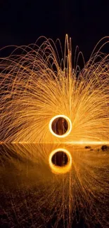 Vibrant orange firework art with reflections on a night sky backdrop.