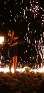 Person stands amidst vibrant fireworks display on a rocky surface at night.