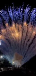 Vibrant fireworks burst with blue and golden hues in the night sky.