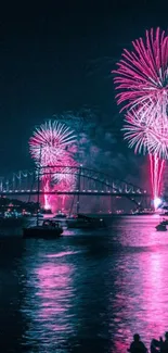 Brilliant pink fireworks explode over a nighttime bridge scene.