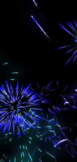 Vibrant blue and green fireworks on a dark background, ideal for festive wallpapers.