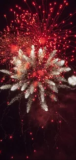 Fireworks explode in vibrant red and white against a night sky background.