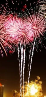 Vibrant fireworks burst over a city at night.