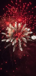 Red and white fireworks burst in night sky.