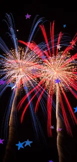 Red and blue fireworks burst against a dark sky in mobile wallpaper.