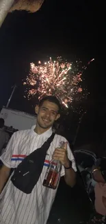 Man enjoying fireworks at night festival with a crowd.