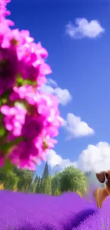 Puppy in vibrant flower field with blue sky and clouds.