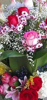 Lush bouquet with red and pink roses amid green leaves.