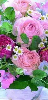 A vibrant bouquet of pink roses, daisies, and green leaves in a vase.