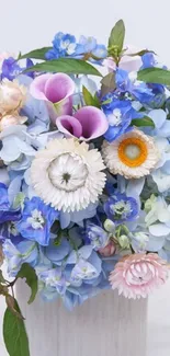 Vibrant bouquet of blue and pink flowers in vase.