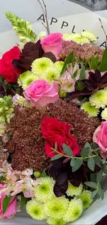 A vibrant bouquet of pink and red flowers with lush greenery.