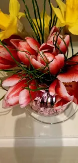 Vibrant bouquet with tulips and daffodils in a vase.