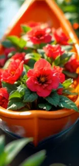 An orange canoe filled with vibrant red flowers on water.