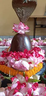 Shiva Lingam adorned with vibrant pink and red flowers, capturing cultural beauty.