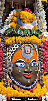 Floral adorned deity statue with vibrant colors and intricate design.