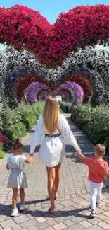 Family walking through vibrant floral garden path.