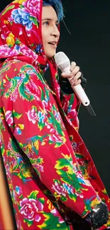 Stylish person in vibrant red floral hoodie on stage.