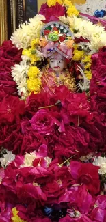 Vibrant floral deity idol with colorful flowers.