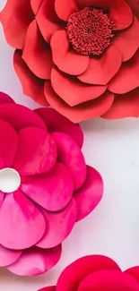 Colorful paper flowers in pink and red hues, creating a vibrant wallpaper.