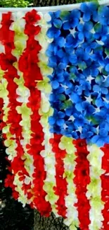 Floral USA flag design with vibrant red, white, and blue flowers hanging on a tree.