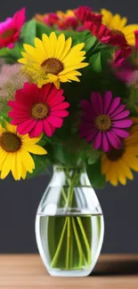 Vibrant daisies in a glass vase on a wooden table, colorful floral wallpaper.