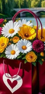 Colorful bouquet of daisies and roses in a pink heart bag by the lake.