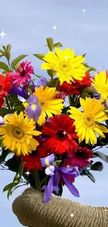 Vibrant bouquet of yellow, red, and purple flowers against a blue sky.