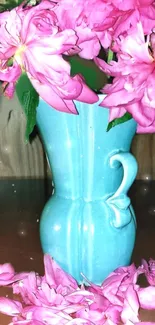 Pink flowers in a blue vase with wood background.