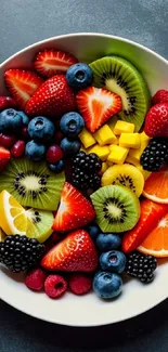 Colorful fruit bowl wallpaper with strawberries, kiwis, and citrus slices.