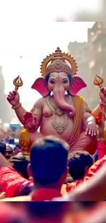 Ganesha statue during lively festival celebration with crowd.