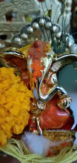 Colorful Ganesh idol with marigolds in vibrant festival setting.