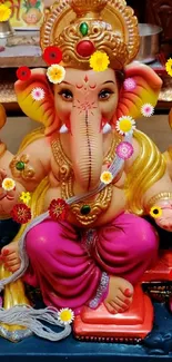 Colorful Ganesh idol with vivid pink attire on display.