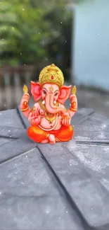 Vibrant Ganesha statue mobile wallpaper in orange hues.