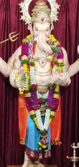 Lord Ganesha adorned with colorful garlands in a vibrant display.