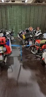 Motorcycles parked in a vibrant garage with colorful vehicles.