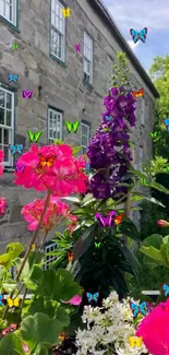 Colorful garden flowers by stone building on a sunny day.