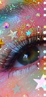 Vibrant glitter eye art with colorful stars and moon details on a pink background.