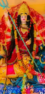 Vibrant depiction of Goddess Durga in traditional attire on a red background.