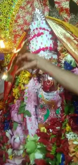 Colorful Hindu goddess idol adorned with flowers and decorations.