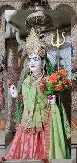 Goddess statue in colorful attire with a temple backdrop.