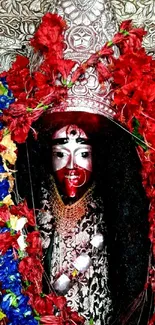 Goddess Kali adorned with vibrant red flowers and cultural ornaments.