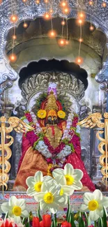 Vibrant decorated goddess in temple with colorful floral arrangement.